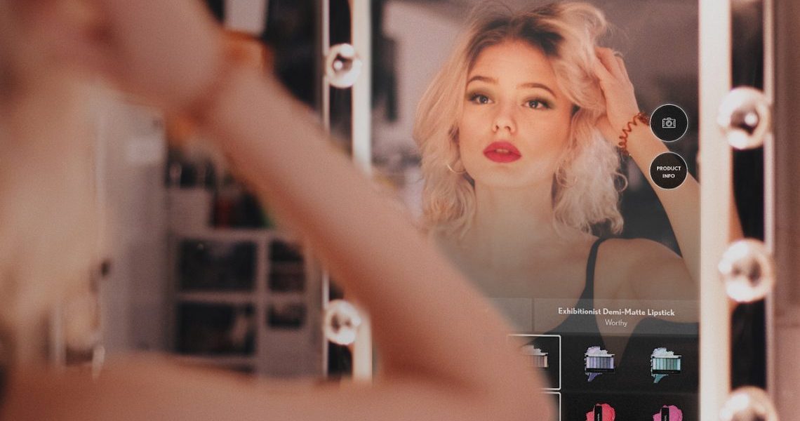 Photograph of a woman using the Covergirl magic mirror.