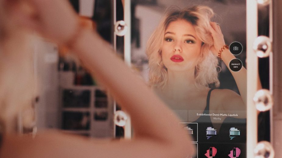 Photograph of a woman using the Covergirl magic mirror.