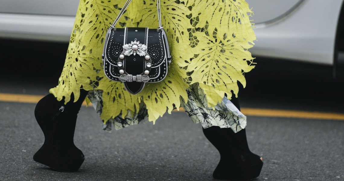 The lead image shows a person walking down a runway at a fashion show.