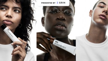 a featured image for a glossy pop story that is sponsored by Grin. The image shows three people holding Yves Saint Laurent beauty products.