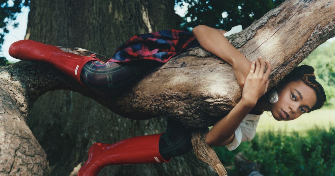 Photograph of a woman in a tree wearing Hunter Boots.