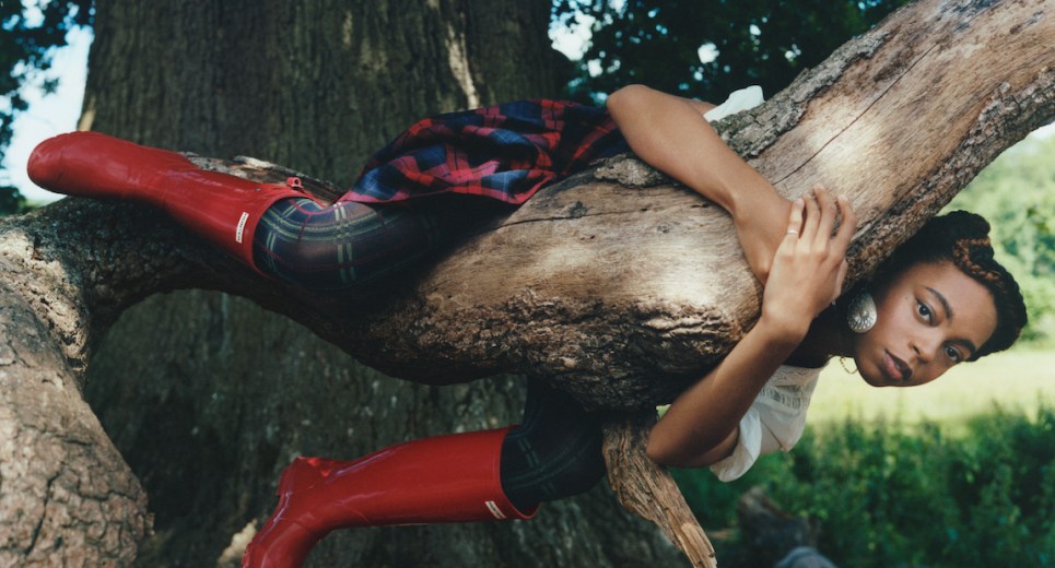Photograph of a woman in a tree wearing Hunter Boots.