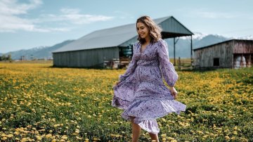 Photograph of a woman walking through a field.