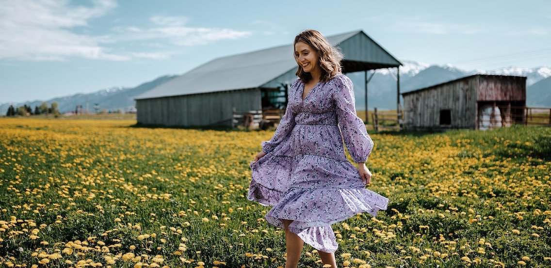 Photograph of a woman walking through a field.