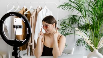influencer girl recording herself with a ring light. Creating user generated content (UGC) showing her glasses for cyber monday and black friday sales.