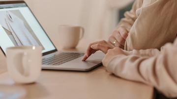 Two people browsing a fashion website on a laptop, illustrating how AI in customer service supports seamless online shopping experiences.