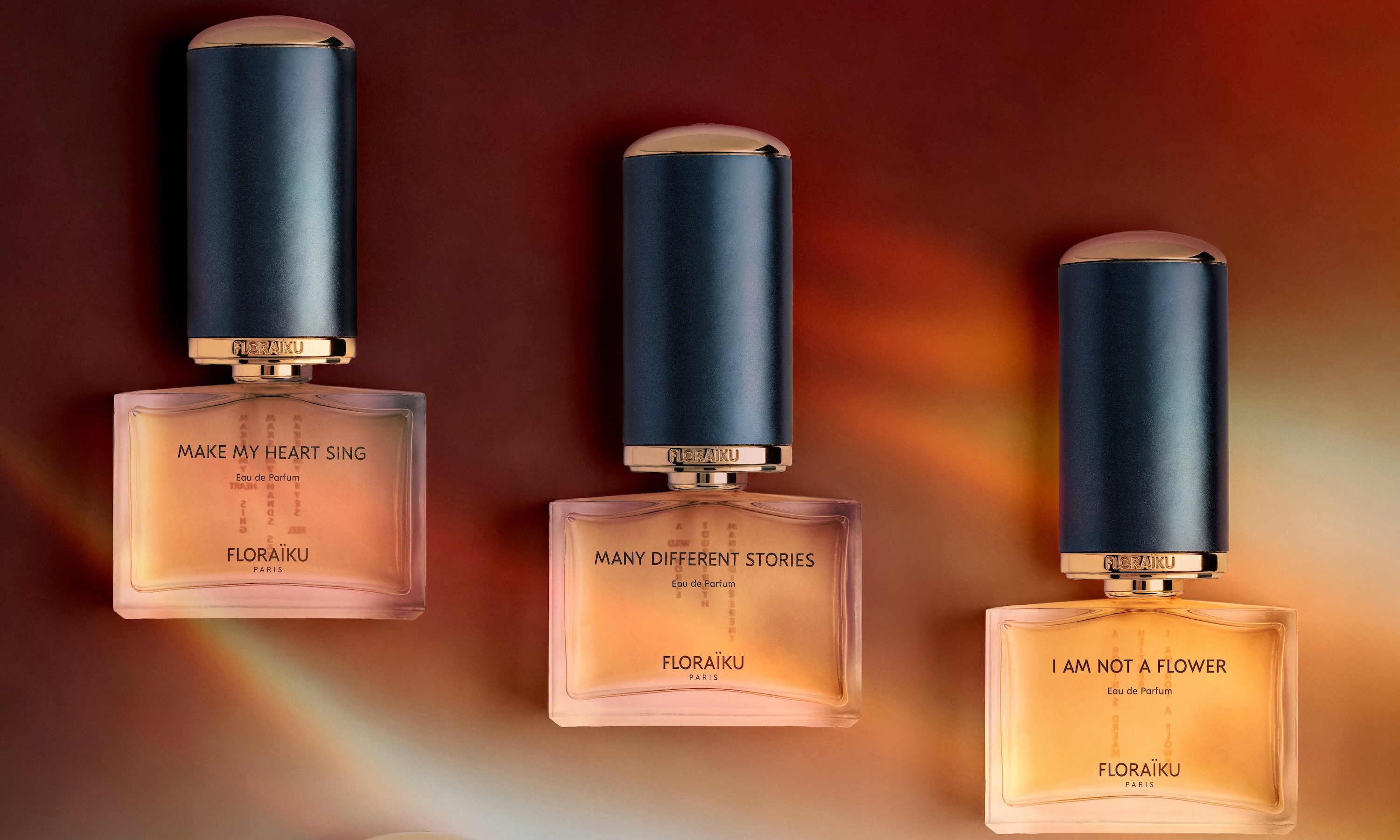 Three perfume bottles standing on a warm lit surface